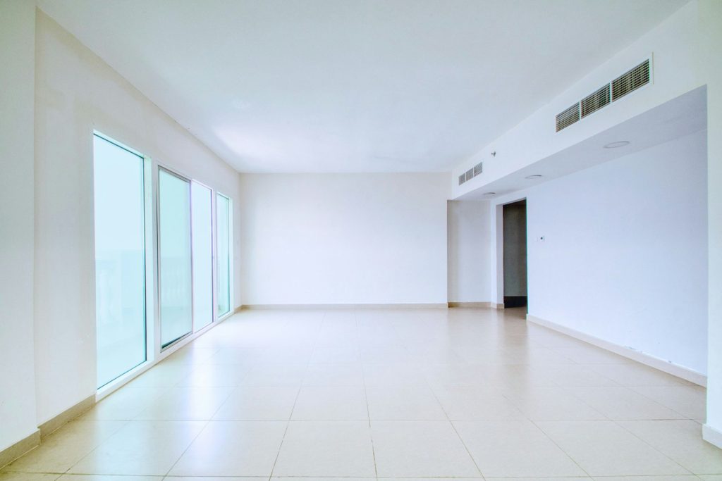 A bright, empty room with large windows.
